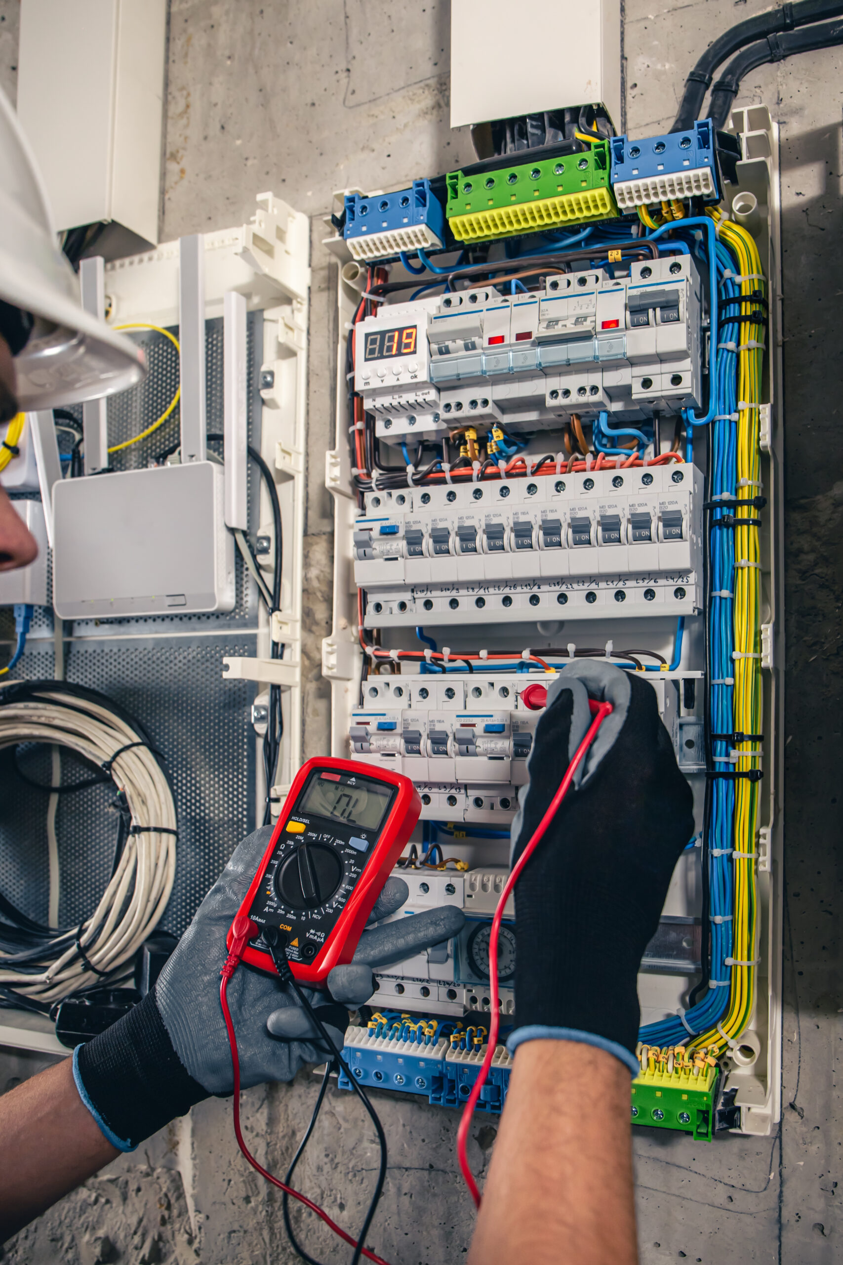 Man, an electrical technician working in a switchboard with fuses. Man, an electrical technician working in a switchboard with fuses. Installation and connection of electrical equipment. Professional uses a tablet. Image by pvproductions on Freepik